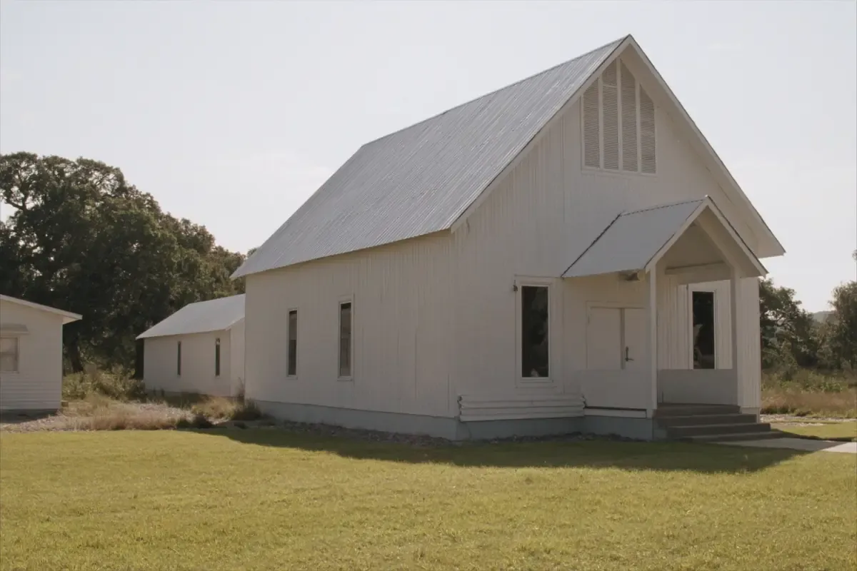 White church building with a metal roof and a gabled porch in the San Antonio area, Texas